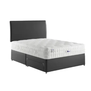 A detailed product image showing the internal layers of the Luxury Wool 2150 mattress, including the pocket springs and wool layers. The image also displays the full mattress on a divan base in a bedroom setting, highlighting its hand-tufted finish and a tag with "10" indicating a 10-year warranty.