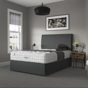 A detailed product image showing the internal layers of the Luxury Wool 2150 mattress, including the pocket springs and wool layers. The image also displays the full mattress on a divan base in a bedroom setting, highlighting its hand-tufted finish and a tag with "10" indicating a 10-year warranty.