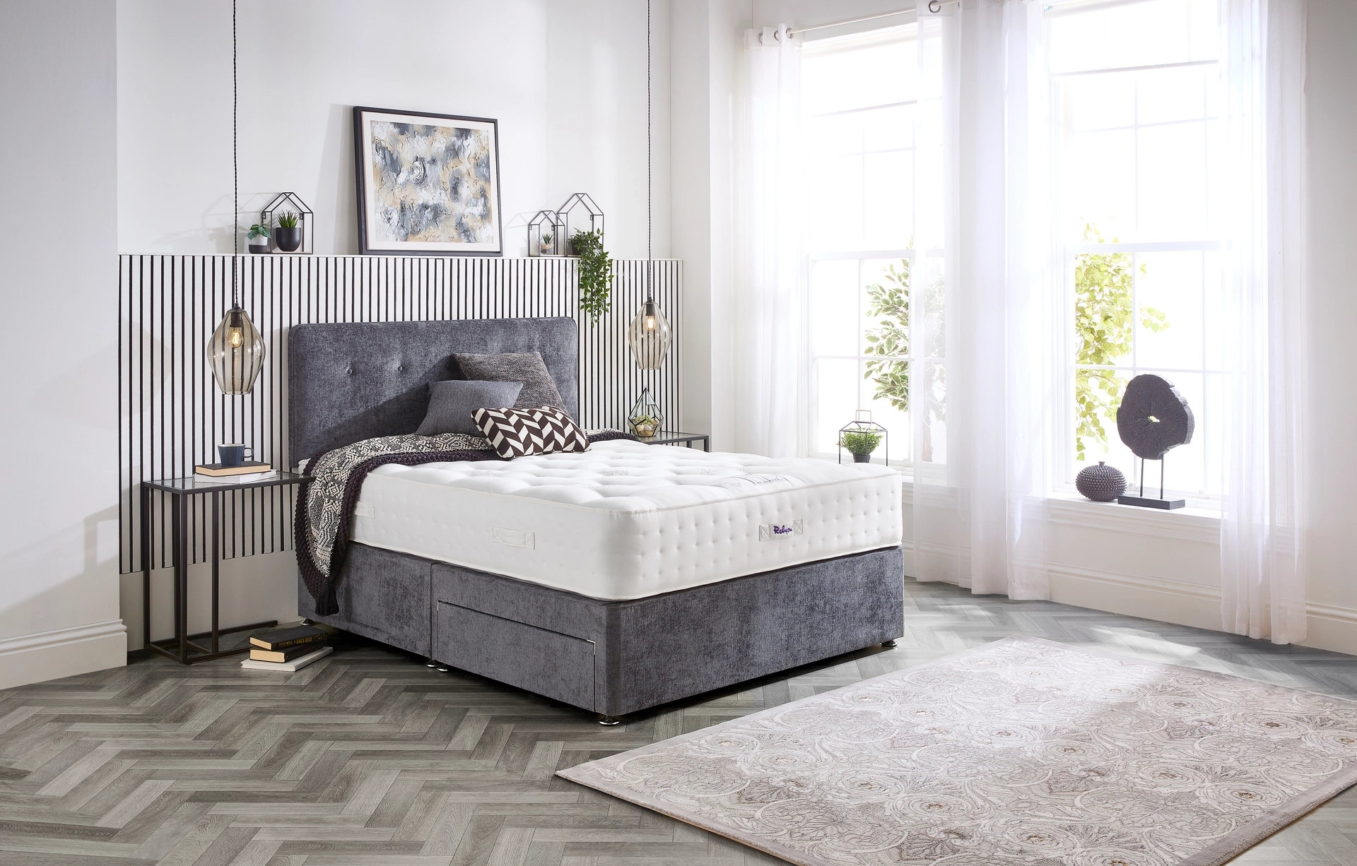 A detailed product image showing the internal layers of the Natural Luxury 1400 Deluxe mattress, including the pocket springs, foam, and natural fillings. The image also displays the full mattress on a divan base in a bedroom setting, highlighting its elegant finish and a tag with "10" indicating a 10-year warranty.