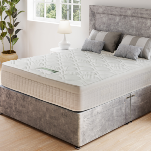 A product image of the Natural Comfort mattress, showing a close-up of its quilted surface and the natural fillings of wool, cashmere, and silk. The image includes three smaller photos showing the raw fillings for visual emphasis.