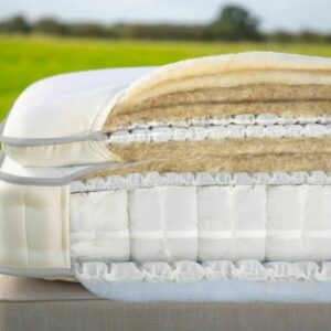 A screenshot of the Harrison Spinks Asscher Pillowtop 11,000 mattress product page. The images show a full mattress on a pink divan base, a close-up of the mattress's quilting, and a list of key features including 11,000 springs and natural fillings.