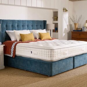 A screenshot of the Harrison Spinks Emerald 16,500 mattress product page. The images show a full mattress on a blue divan base, a close-up of the mattress's quilting, and a list of key features including 16,500 springs and natural fillings.