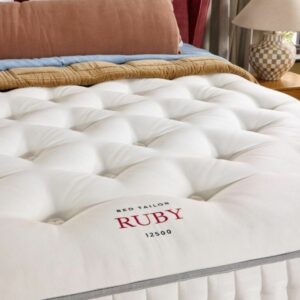 A screenshot of the Harrison Spinks Ruby 12,500 mattress product page. The images show a full mattress on a red divan base, a close-up of the mattress's quilting, and a list of key features including 12,500 springs and natural fillings.