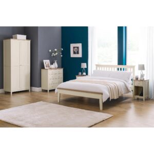 A full shot of the Salerno Shaker Bed, showing its two-tone finish with an ivory lacquer frame and solid white oak cappings on the headboard and footboard. The bed is styled with white bedding in a bedroom with a dark blue feature wall.