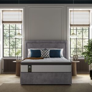 A beautifully upholstered headboard with a prominent central panel surrounded by a heavily padded border, shown in a light blue fabric.