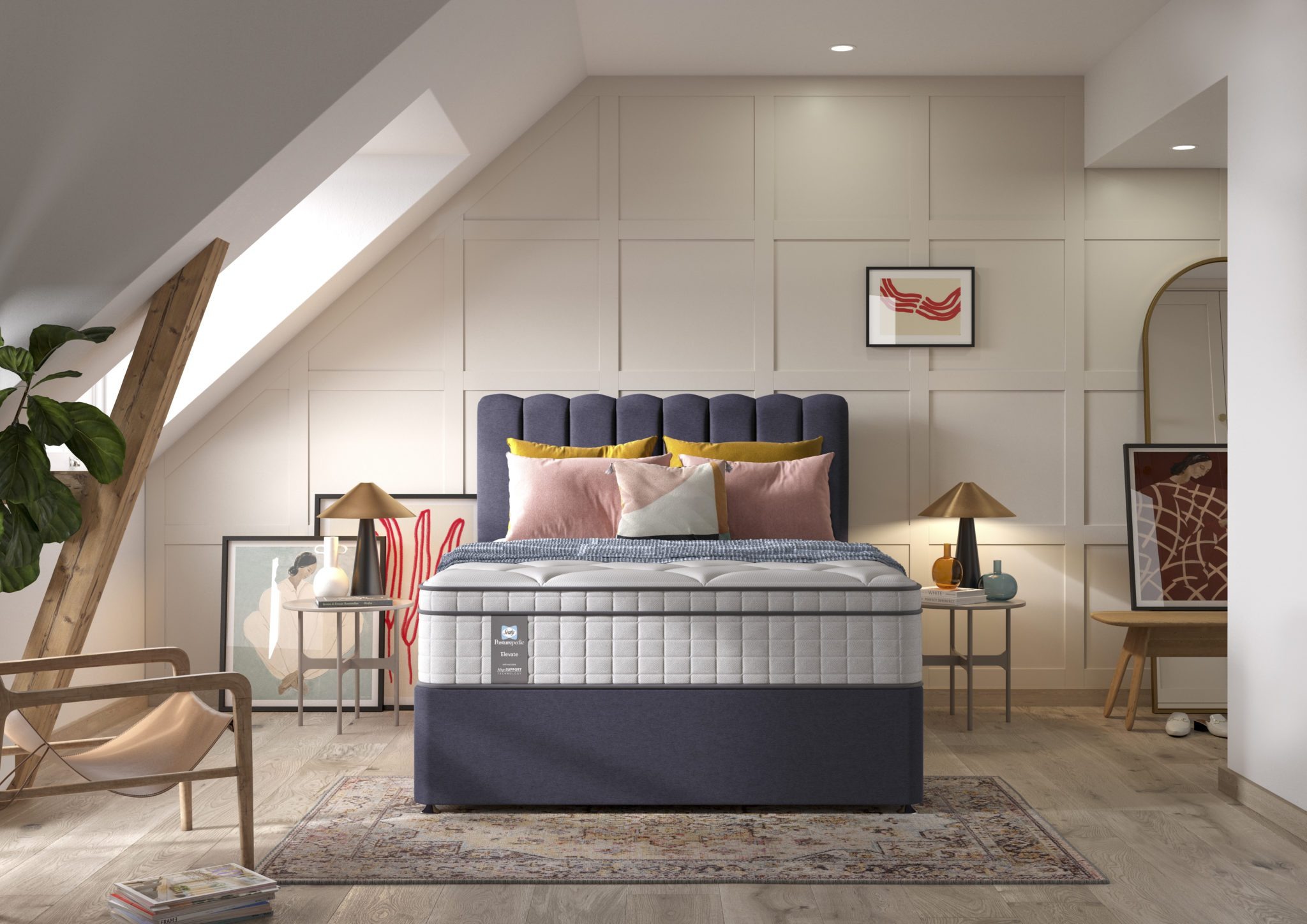 A full shot of the Spencer Plush Mattress, shown on a dark blue divan base with a tall, contemporary upholstered headboard, set in a bright bedroom with light wood wall panelling. The mattress has a deep quilted white top.