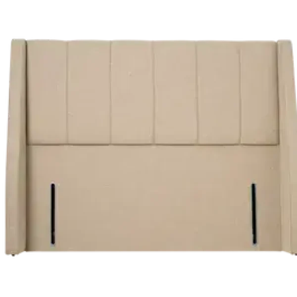A luxurious, extra-wide upholstered headboard with six deeply cushioned vertical panels and wrap-around wings, shown in a light, neutral-colored fabric. The headboard is shown against a plain grey background.