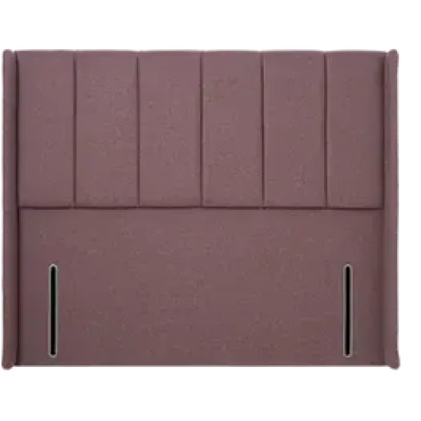 A striking, extra-wide upholstered headboard with seven deeply cushioned vertical panels and wrap-around wings, shown in a mauve/pink-colored fabric. The headboard is shown against a plain grey background.