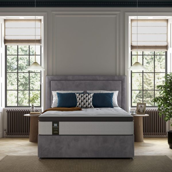 A beautifully upholstered headboard with a prominent central panel surrounded by a heavily padded border, shown in a light blue fabric.