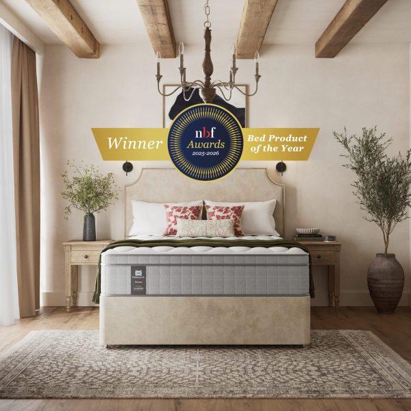 A luxurious shot of the Edison Luxury Plush Mattress, placed on a classic divan base with a curved upholstered headboard, featuring a large "NBF Awards - Bed Product of the Year" winner badge prominently displayed over the bed. The mattress has a deep quilted white top.